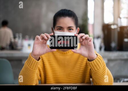 CHIANG mai, THAILANDIA Apr 14 2021 : mano che tiene Apple iPhone con il logo Netflix su uno schermo. Netflix è un fornitore globale di film in streaming e TV Foto Stock