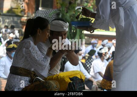 Giacarta, Giacarta, Indonesia. 14 Apr 2021. Gli indù balinesi celebrano la giornata di Galungan con una cerimonia a pura Aditya Jaya, Rawamangun, Giacarta, il 14 aprile 2021. Galungan Day è un giorno in cui gli Indù commemorano la creazione dell'universo e tutti i suoi contenuti e grazie, gli Indù danno e fanno offerte a Sang Hyang Widhi e Dewa Bhatara, come il giorno della vittoria per Dharma (verità) contro Adharma Credit: Dasril Roszandi/ZUMA Wire/Alamy Live News Foto Stock