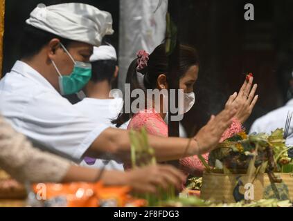 Giacarta, Giacarta, Indonesia. 14 Apr 2021. Gli indù balinesi celebrano la giornata di Galungan con una cerimonia a pura Aditya Jaya, Rawamangun, Giacarta, il 14 aprile 2021. Galungan Day è un giorno in cui gli Indù commemorano la creazione dell'universo e tutti i suoi contenuti e grazie, gli Indù danno e fanno offerte a Sang Hyang Widhi e Dewa Bhatara, come il giorno della vittoria per Dharma (verità) contro Adharma Credit: Dasril Roszandi/ZUMA Wire/Alamy Live News Foto Stock