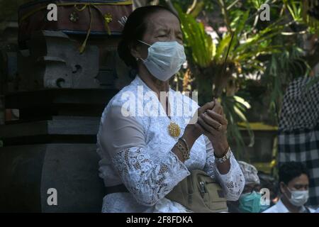 Giacarta, Giacarta, Indonesia. 14 Apr 2021. Gli indù balinesi celebrano la giornata di Galungan con una cerimonia a pura Aditya Jaya, Rawamangun, Giacarta, il 14 aprile 2021. Galungan Day è un giorno in cui gli Indù commemorano la creazione dell'universo e tutti i suoi contenuti e grazie, gli Indù danno e fanno offerte a Sang Hyang Widhi e Dewa Bhatara, come il giorno della vittoria per Dharma (verità) contro Adharma Credit: Dasril Roszandi/ZUMA Wire/Alamy Live News Foto Stock