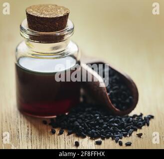 Nigella semi e olio essenziale in una bottiglia di vetro Foto Stock