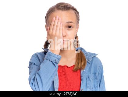 Felice ragazza adolescente guarda con un occhio mentre copre l'altro occhio con la sua mano, isolato su sfondo bianco Foto Stock