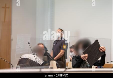 Augusta, Germania. 14 Apr 2021. Una donna disimballa un file nel dock nella sala della giuria. Gli imputati sono accusati di aver accusato le compagnie di assicurazione di assistenza infermieristica di milioni di persone tramite fatturazione per i servizi di assistenza che non sono stati forniti. Credit: Stefan Puchner/dpa - ATTENZIONE: Gli imputati sono stati pixelated per ordine della difesa/dpa/Alamy Live News Foto Stock
