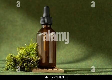 Flacone per siero cosmetico con pipetta su fondo verde naturale Foto Stock
