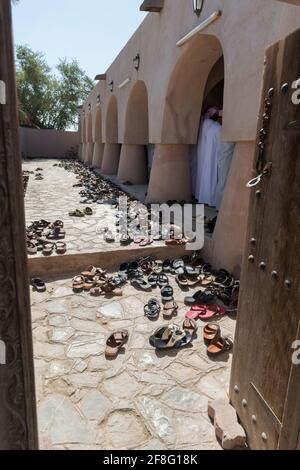 Un sacco di scarpe vicino alla sala di preghiera della moschea Jami al Hamoda nella città Jalan Bani ben Ali. Sharqiyah sud Governatorato di Ash. Oman Foto Stock