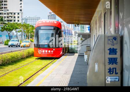 Sanya China, 24 marzo 2021: Tram rosso di Sanya che lascia una stazione a Sanya Hainan Cina Foto Stock