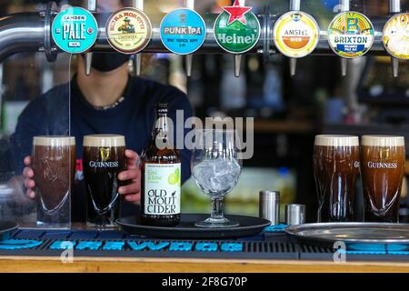 Londra, Regno Unito. 12 Aprile 2021. Un barmaid prepara le pinte di Guinness in un pub a Londra. Credit: SOPA Images Limited/Alamy Live News Foto Stock