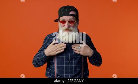 Nonno alato maturo in occhiali da sole che mostrano lo spreco o il lancio soldi intorno al gesto della mano Foto Stock