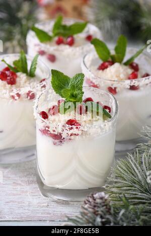 Mojito bianco di Natale a base di liquore, tequila, latte di cocco con semi di melograno, fiocchi di cocco e menta rinfrescante. Foto Stock