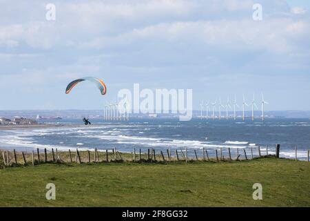 Parapendio con il Teesside Offshore Windfarm Beyond, Redcar, North Yorkshire, Regno Unito Foto Stock