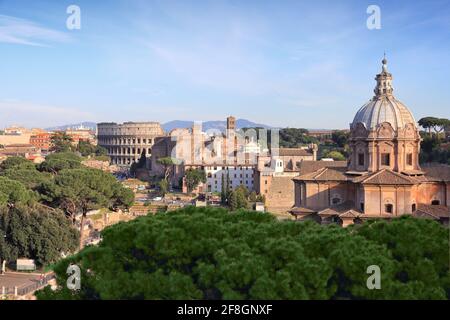 Colosseo a Roma, Italia. Rione Monti - il paesaggio urbano con il Colosseo nel quartiere Monti, Roma. Santi Luca e Martina sulla destra. Foto Stock
