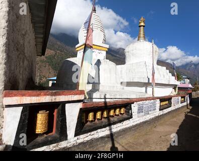 Stupa con bandiere di preghiera e ruote sulla strada da Lukla a Namche bazar in chaurikharka vicino villaggio chheplung - nepal Foto Stock