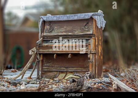 Pianoforte in legno rovinato nel mezzo di un fronte residenziale prato Foto Stock