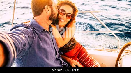 Selfie immagine con coppia gioiosa baciarsi e divertirsi insieme in tour escursione in barca - concetto di persone innamorate e vacanza turistica - blu oceano Foto Stock
