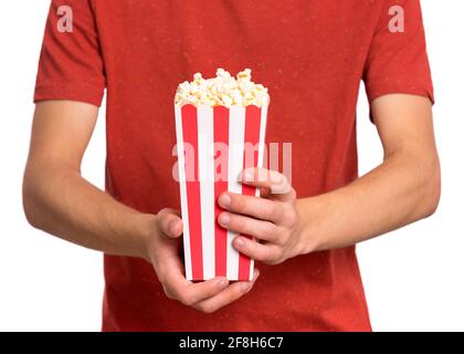 Le mani del ragazzo teenager con il secchio del popcorn, lo sfondo bianco isolato. Il bambino si prepara a guardare il film mentre tiene il popcorn. Primo piano Foto Stock