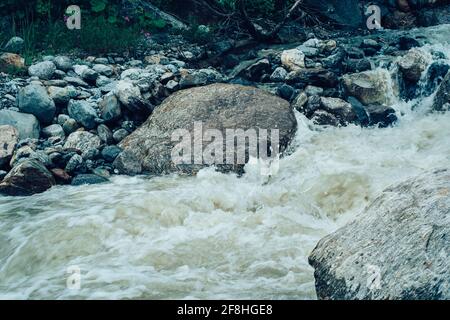 Primo piano del flusso rapido e pulito che scorre sulle rocce. Il fiume di montagna scorre giù e spruzzi Foto Stock