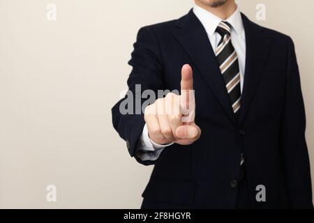 Una mano dell'uomo in una tuta che aziona il touch panel Foto Stock