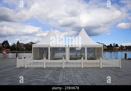 Schleswig-Holstein, Eckernförde: 14 aprile 2021, il padiglione recintato con tavoli e sedie per la ristorazione all'aperto di un ristorante si trova alla punta del porto. Foto: Christian Charisius/dpa Foto Stock