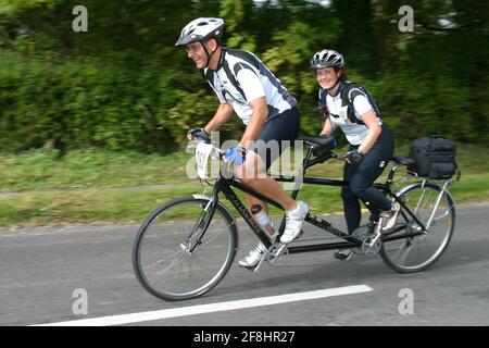 Due ciclisti su un tandem alimentano una collina. Andover Hampshire UK. Foto Stock