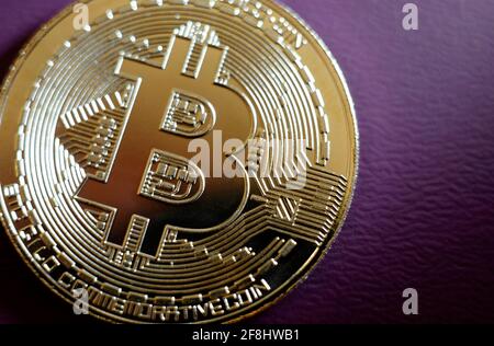 moneta bitcoin placcata oro su sfondo viola Foto Stock