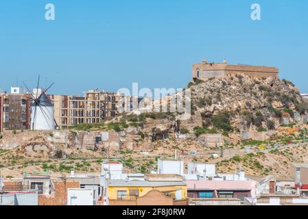 Mulino a vento e fortezza sul Monte Sacro visto dal parco archeologico sul cerro del molinete a Cartagena, Spagna Foto Stock