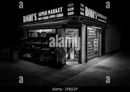 negozio d'angolo tradizionale, edicola e minimarket di notte a londra, immagine notturna in bianco e nero Foto Stock