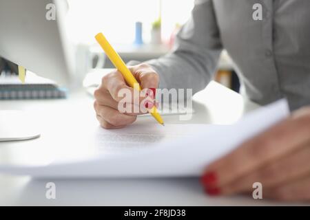 La mano della donna tiene il documento della penna e dei segni Foto Stock