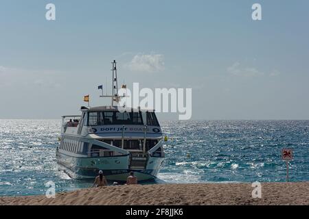 Lloret De Mar, Spagna - 03 aprile 2021: Una barca da diporto ormeggia su una spiaggia di sabbia. Foto di scorta. Foto Stock