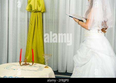 Una sposa ebraica si trova accanto alla finestra davanti all'Hupa cerimonia in un matrimonio Foto Stock