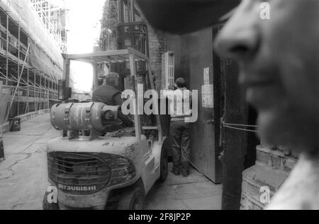 operai che appendono il radiatore sabbiato all'esterno dell'unità di fabbrica utilizzando un carrello elevatore a forche Foto Stock