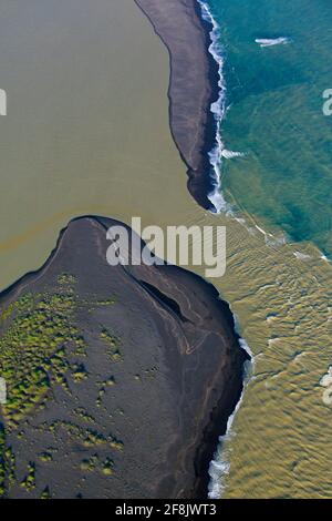 Vista aerea su Landeyjarsandur che mostra la spiaggia con sabbia vulcanica nera e acqua marrone carico di sedimenti che fluiscono in mare in estate, Islanda Foto Stock