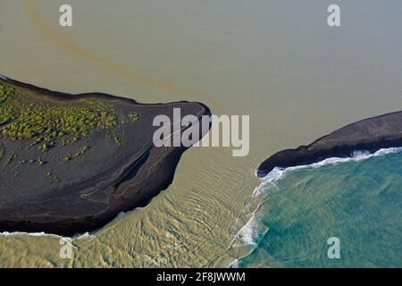 Vista aerea su Landeyjarsandur che mostra la spiaggia con sabbia vulcanica nera e acqua marrone carico di sedimenti che fluiscono in mare in estate, Islanda Foto Stock