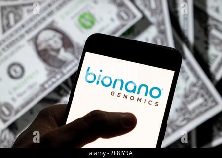 In questa illustrazione della foto, la piattaforma per analizzare i lunghi segmenti del logo dell'azienda di biotecnologia del DNA genomico Bionano Genomics è visualizzata sullo schermo di un dispositivo mobile Android con la valuta dell'icona del dollaro degli Stati Uniti, simbolo dell'icona in background. Foto Stock