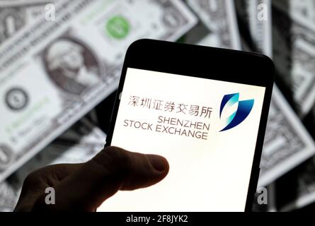 In questa illustrazione fotografica, il logo dell'indice di borsa di Shenzhen è visualizzato sullo schermo di un dispositivo mobile Android con la valuta dell'icona del dollaro degli Stati Uniti, simbolo dell'icona in dollari sullo sfondo. Foto Stock