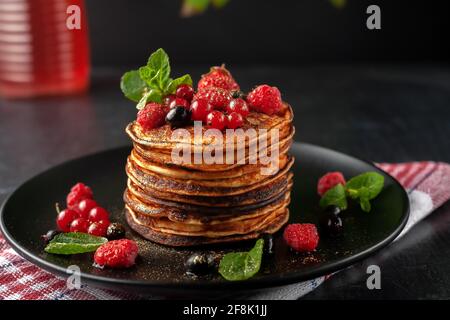 Deliziosi pancake fatti in casa con lamponi freschi, ribes e fragole Foto Stock