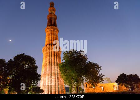 Silhouette di Qutub Minar un minareto più alto in India che si erge 73 m di altezza torre rastremata di cinque piani fatta di arenaria rossa. Foto Stock