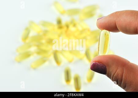 Vitamine. Primo piano di ragazza che tiene la pillola con olio di pesce Omega-3. Nutrizione. Supplementi nutrizionali sani. Sport, concetto di dieta. Foto Stock