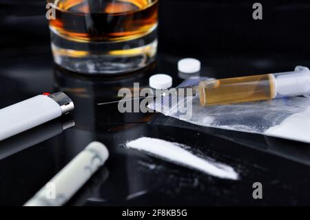 Cocaina, pillole, alcol ed eroina in siringa. Tossicodipendenza. Concetto di veleno. Foto Stock