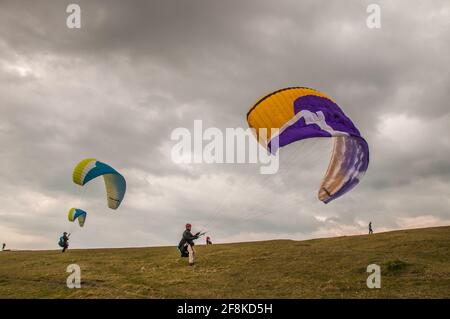 Bo Peep, Alciston, Lewes, East Sussex, Regno Unito. 14 Apr 2021. Un inizio di giornata brillante con la nuvola in aumento nel pomeriggio. Il vento freddo proveniente dal Nord Est porta i piloti di parapendio a Bo Peep sulla via Southdown sopra la gloriosa campagna del Sussex. Credit: David Burr/Alamy Live News Foto Stock