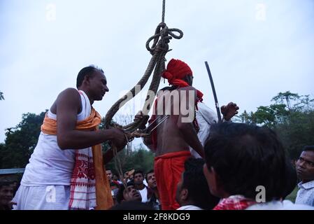 Guwahati, Assam, India. 14 Apr 2021. Devoto indù trafitto con gancio di ferro, durante il festival di Charak Puja in mezzo COVID-19 pandemia di Coronavirus in un villaggio nel distretto di Barpeta di Assam. Charak Puja è un festival folcloristico indù in onore del dio Shiva. Si svolge nello stato indiano del Bengala occidentale e del Bangladesh meridionale l'ultimo giorno del mese di Chaitra, a mezzanotte. Credit: David Talukdar/ZUMA Wire/Alamy Live News Foto Stock