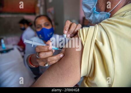 Ghaziabad, India. 14 Apr 2021. Un uomo viene vaccinato presso il Centro sanitario Urbano primario.terzo giorno del Tika Utsav (festival della vaccinazione), secondo il ministero della salute complessivamente 111,179,578 dosi di vaccino sono state somministrate durante tutta la sessione. Credit: SOPA Images Limited/Alamy Live News Foto Stock