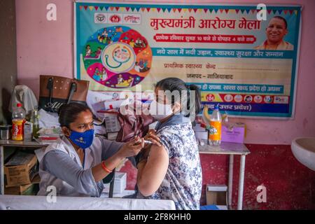 Ghaziabad, India. 14 Apr 2021. Una donna viene vaccinata al Centro sanitario Urbano primario. Terzo giorno del Tika Utsav (festival della vaccinazione), secondo il ministero della salute complessivamente 111,179,578 dosi di vaccino sono state somministrate durante tutta la sessione. Credit: SOPA Images Limited/Alamy Live News Foto Stock