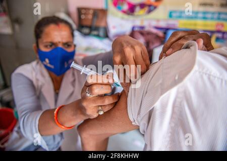 Ghaziabad, India. 14 Apr 2021. Un uomo viene vaccinato presso il Centro sanitario Urbano primario.terzo giorno del Tika Utsav (festival della vaccinazione), secondo il ministero della salute complessivamente 111,179,578 dosi di vaccino sono state somministrate durante tutta la sessione. Credit: SOPA Images Limited/Alamy Live News Foto Stock