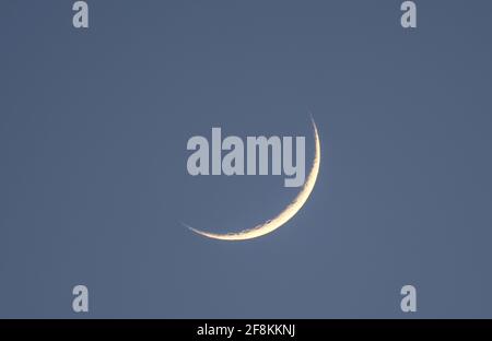 Londra, Regno Unito. 14 aprile 2021. Una sottile Luna Crescent Waxing illuminata al 5% dalla luce solare nel cielo occidentale dopo il tramonto, la prima fase dopo una nuova luna. Credit: Malcolm Park/Alamy Live News Foto Stock