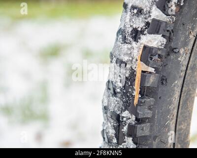 Ruota mtb posteriore con pneumatico grasso per terreni estremi. Primo piano di uno pneumatico della bicicletta. La bicicletta nel luogo della neve invernale Foto Stock