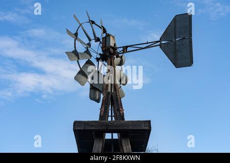 Un antico mulino a vento in stile pionieristico o una pompa a vento con una torre in legno nel Superstition Mountain Museum in Arizona. Foto Stock