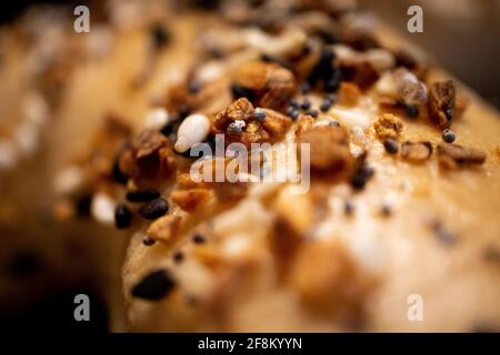 Primo piano estremo di condimento su bagel con semi prominenti Foto Stock
