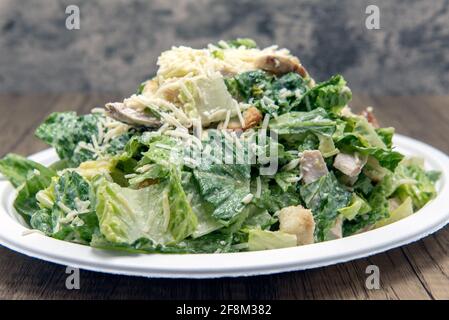 Caesar insalata accatastata con formaggio, lattuga, e condimento per riempire qualsiasi appetito. Foto Stock