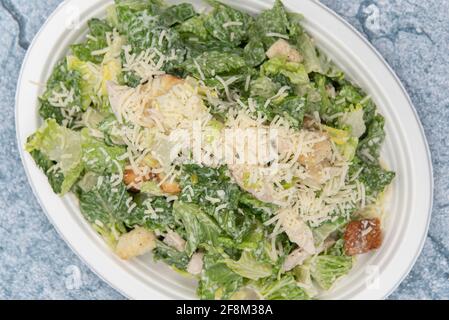 Vista dall'alto dell'insalata caesar con formaggio, lattuga e condimento per riempire l'appetito. Foto Stock