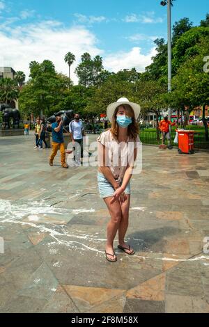 Medellin, Antioquia, Colombia - 6 gennaio 2021: Il turista indossa una maschera e un cappello in Plaza Botero Foto Stock